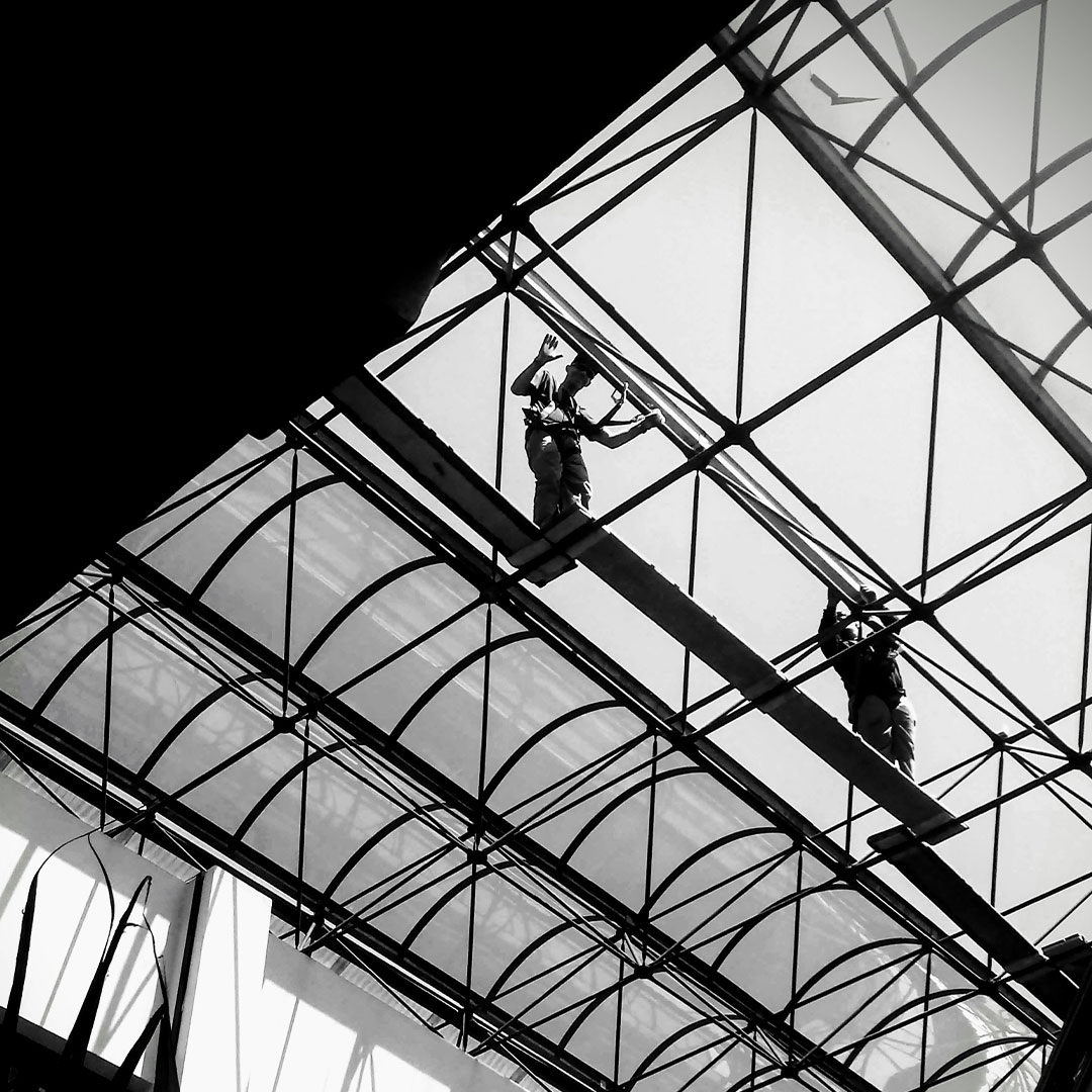Foto preta e branca de uma estrutura arquitetônica com dois trabalhadores da construção