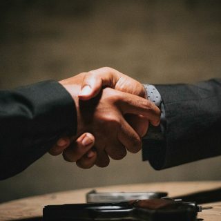 Foto de um aperto de mãos entre dois homens de terno