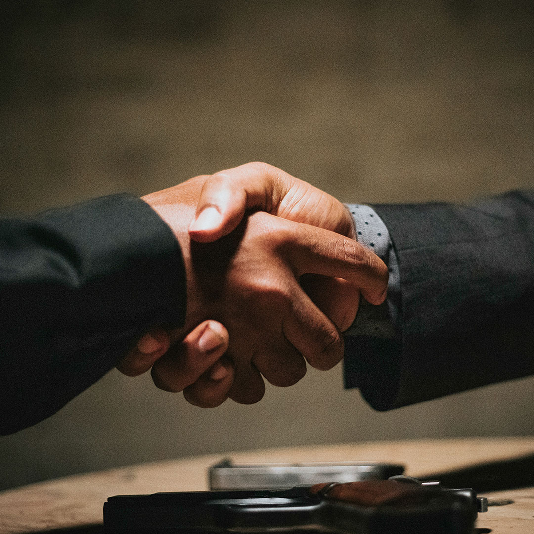 Foto de um aperto de mãos entre dois homens de terno